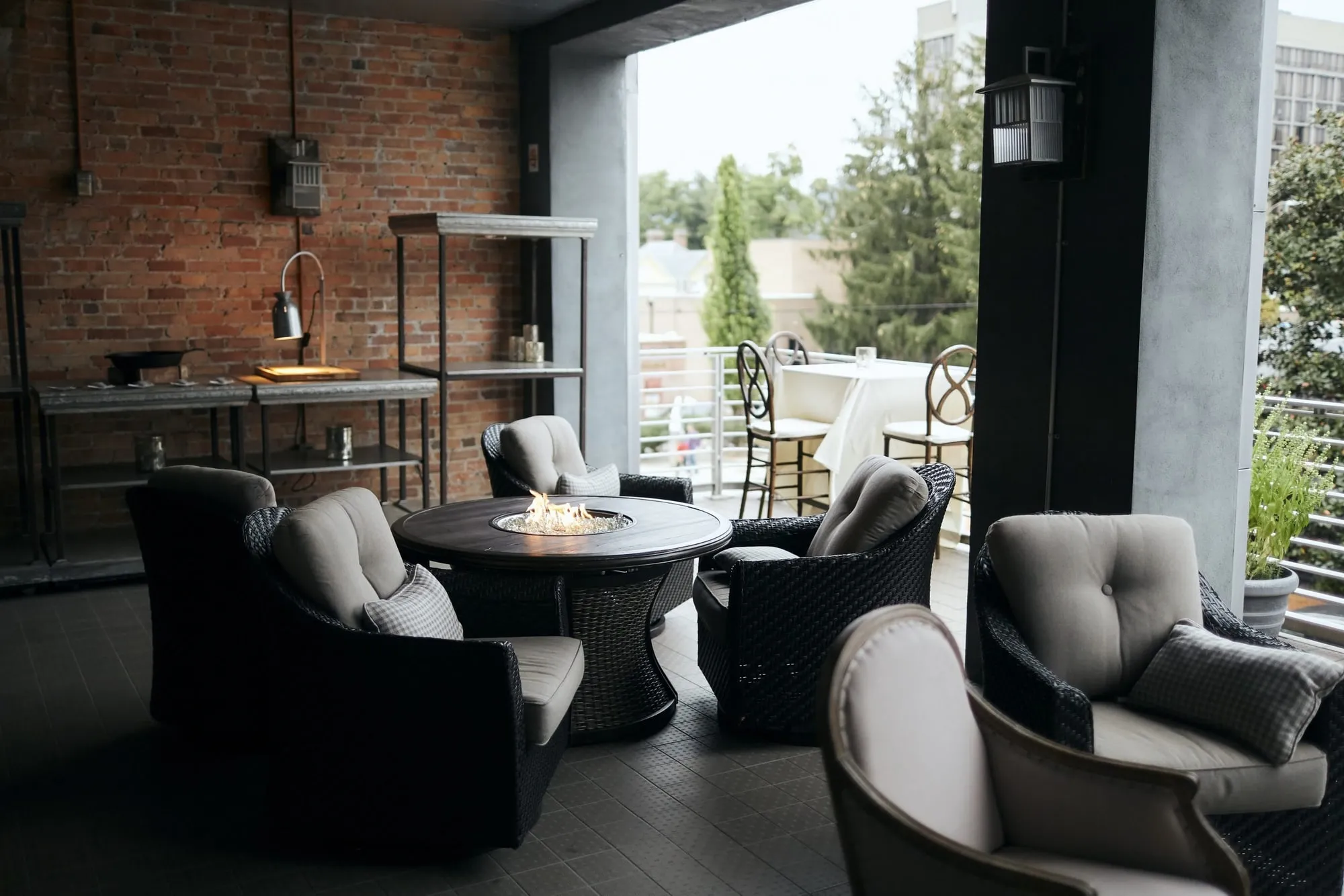 The balcony lounge after dark, low outdoor seating around a fire table