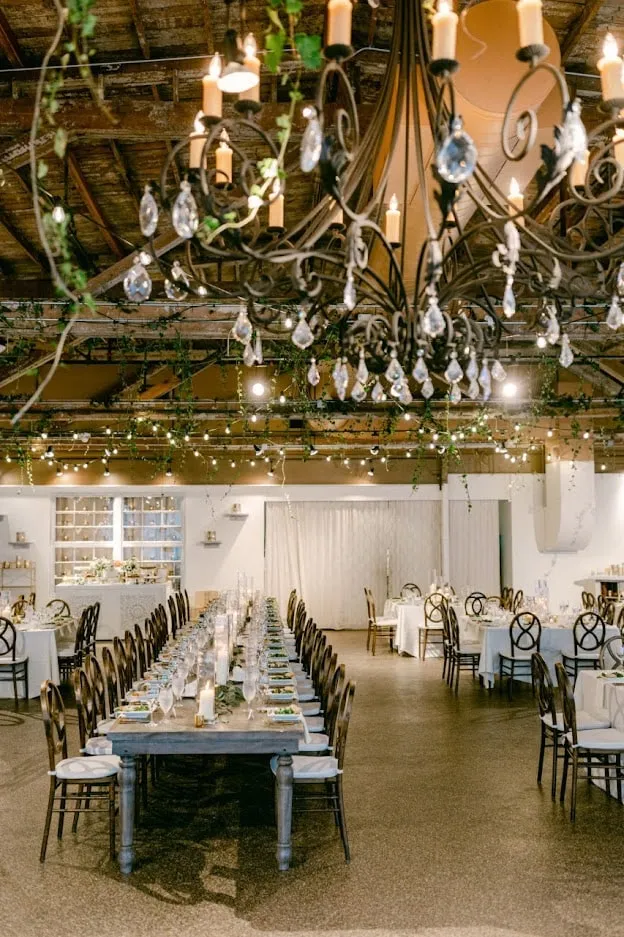 Chandeliers hung with crystal drops over long tables set in white
