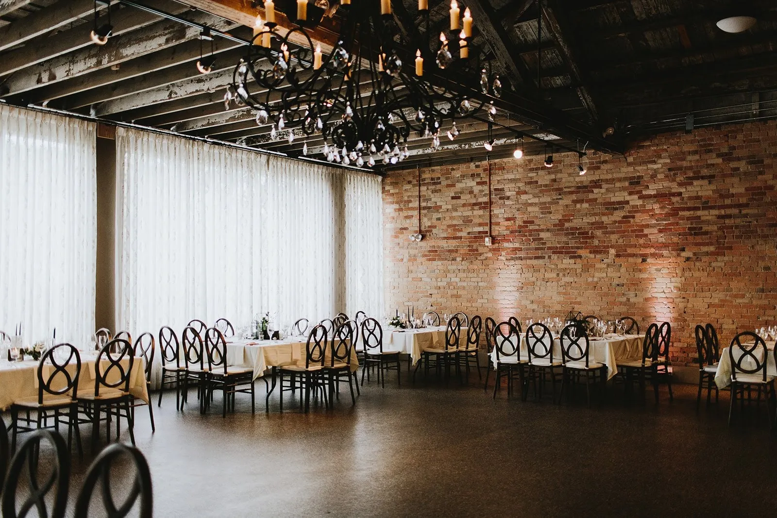 The room mostly empty, white drape along one wall and an open dance floor