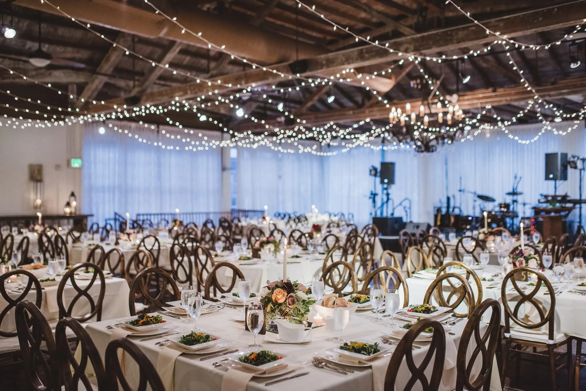 A canopy of string lights over the room, a band set up at the far end
