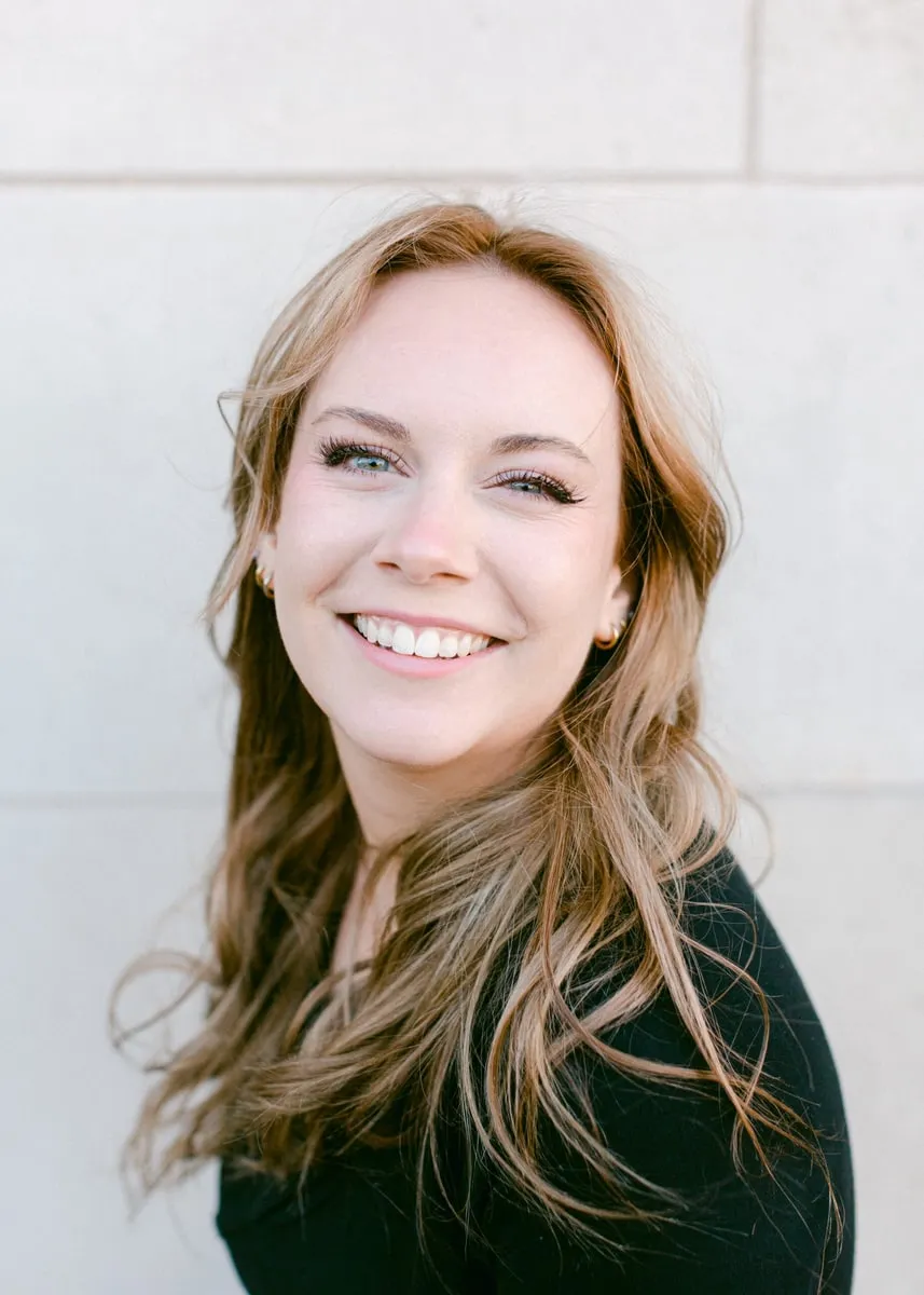 Kendall, event manager at The Venue, in a portrait against a pale stone wall
