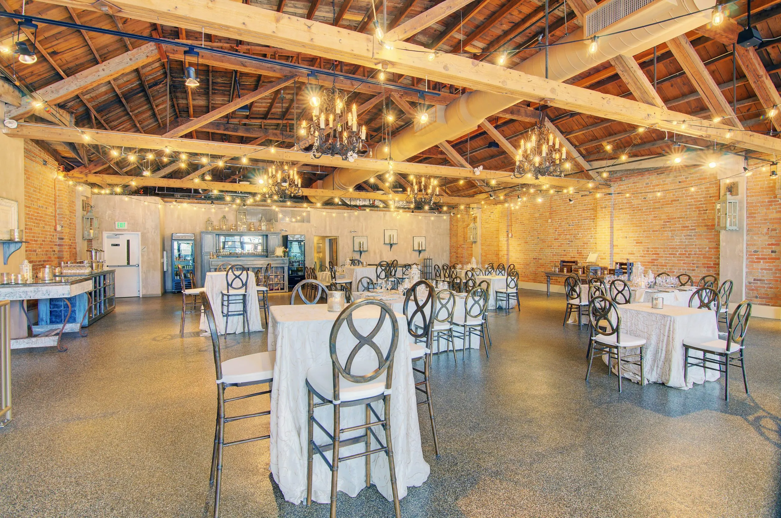 The Second Level set with round tables under its exposed timber roof and string lights