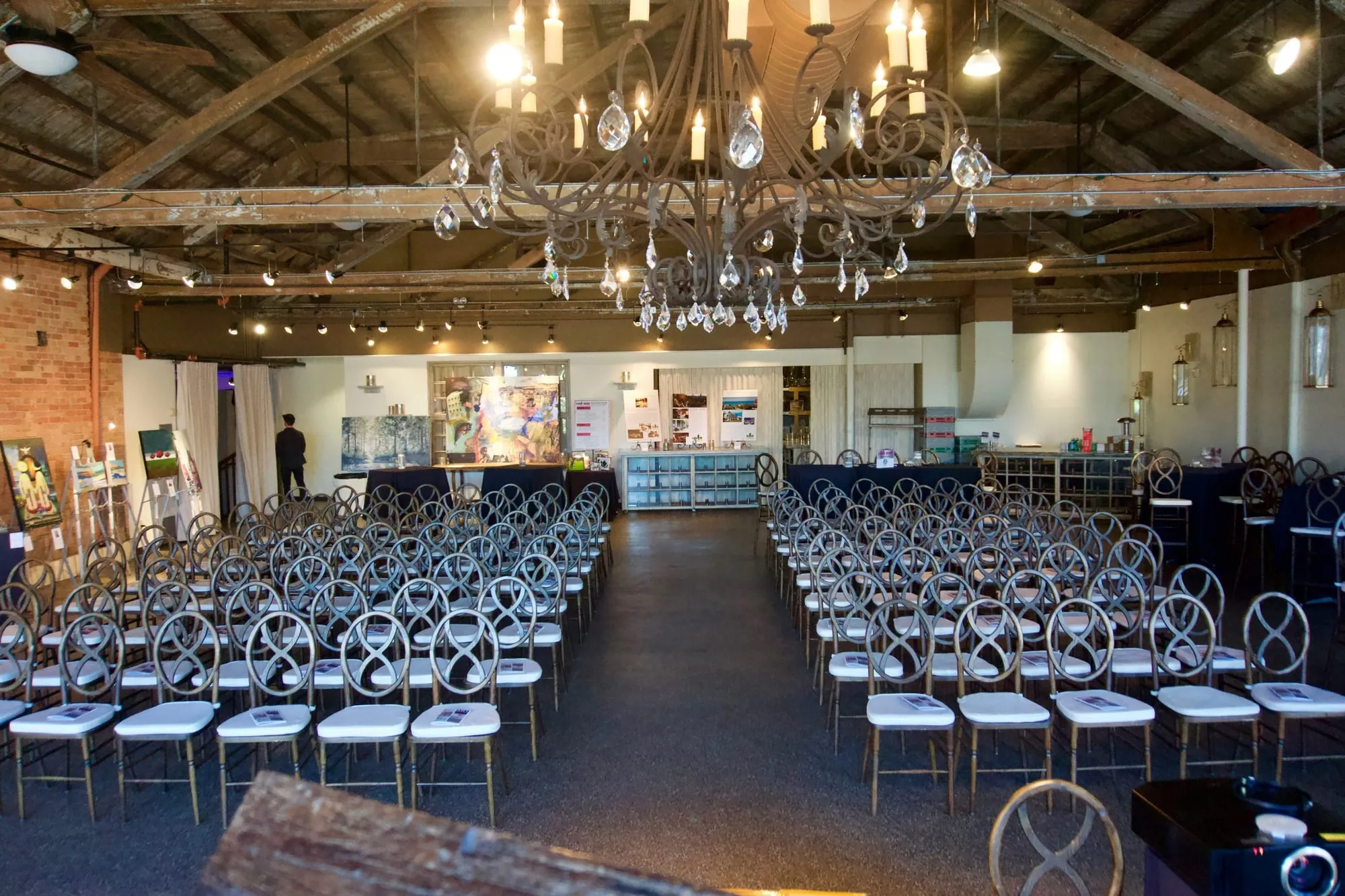 Rows of chairs facing the front of the room beneath crystal chandeliers